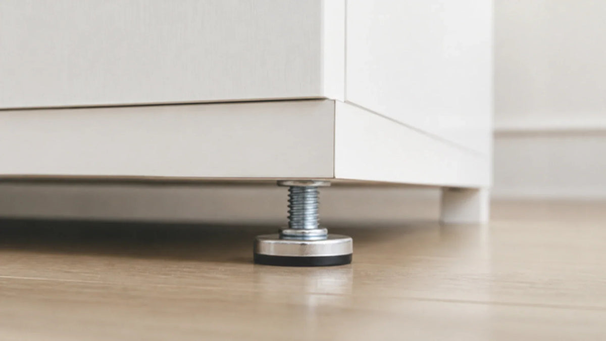 Patín nivelador instalado bajo un mueble